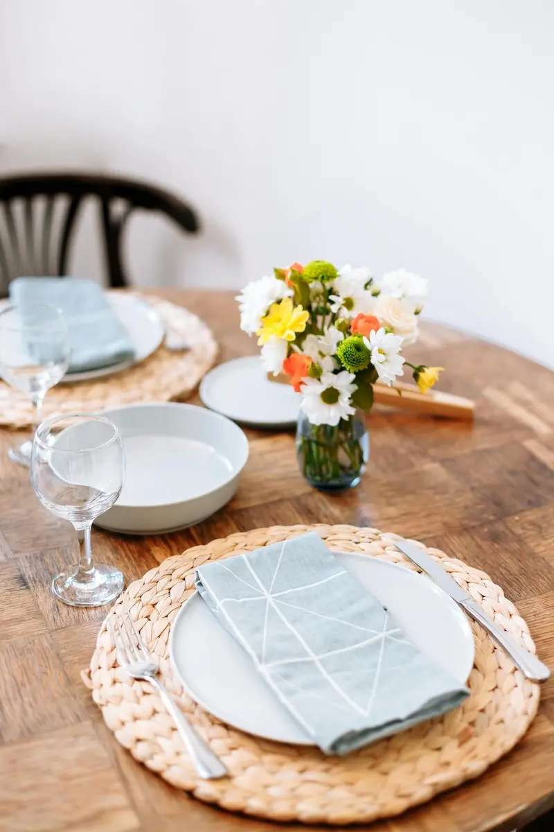 Placement with white plates and blue napkins with a flower vase in a Indiana Dietitian's kitchen